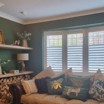 Plantation shutters fitted across a bay window in a living room
