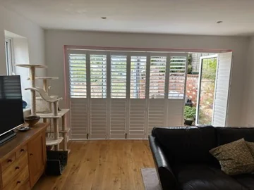 Bi-fold door shutters with one panel folded open to the garden