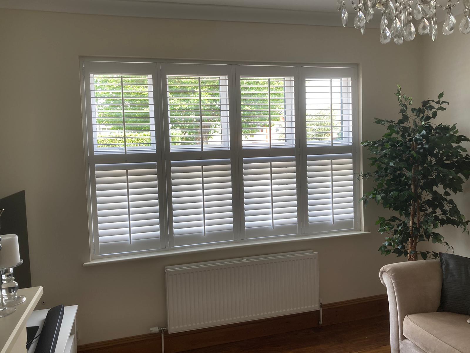 White plantation shutters on a large living room window
