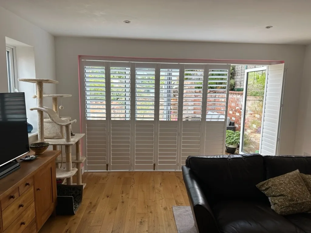 French door shutters with one panel opened to reach the door