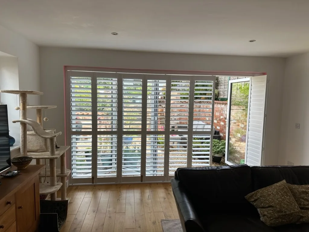 French door shutters closed across the opening with the louvres tilted for light