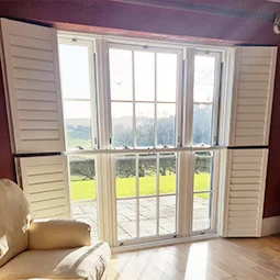 Sunlit room kept cool with plantation shutters