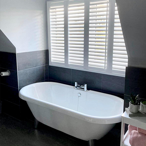 Waterproof Shutters in a bathroom, above a roll-top bath