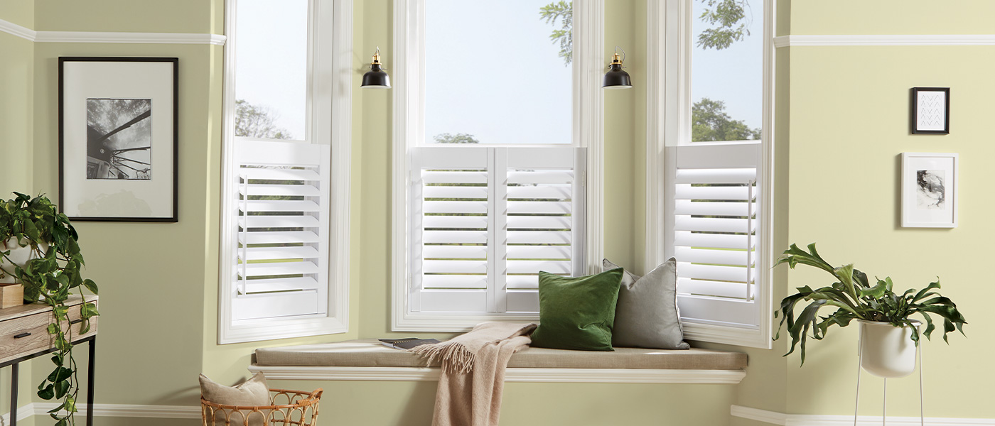 A room with green shutters and a window seat.