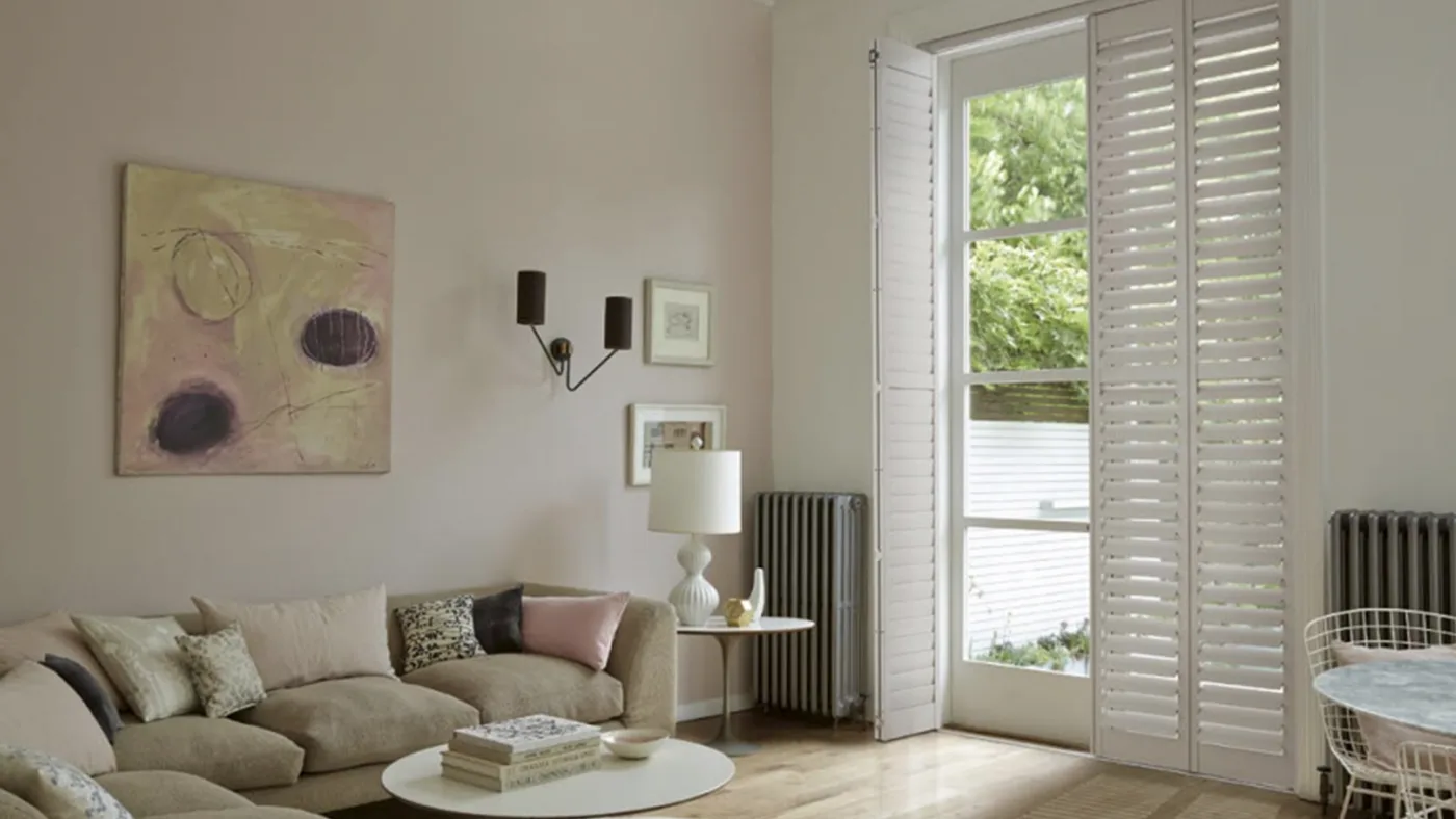 A white living room with wooden shutters.