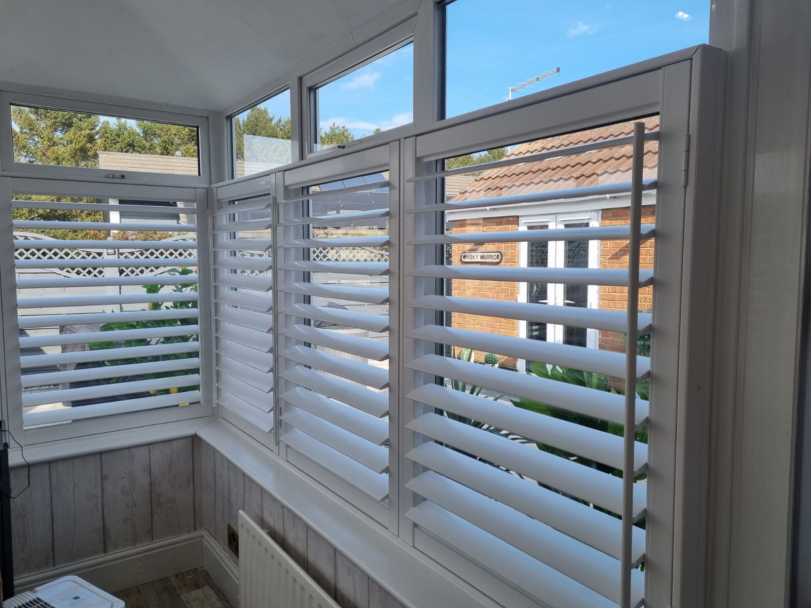 White shutters on a window in a room.