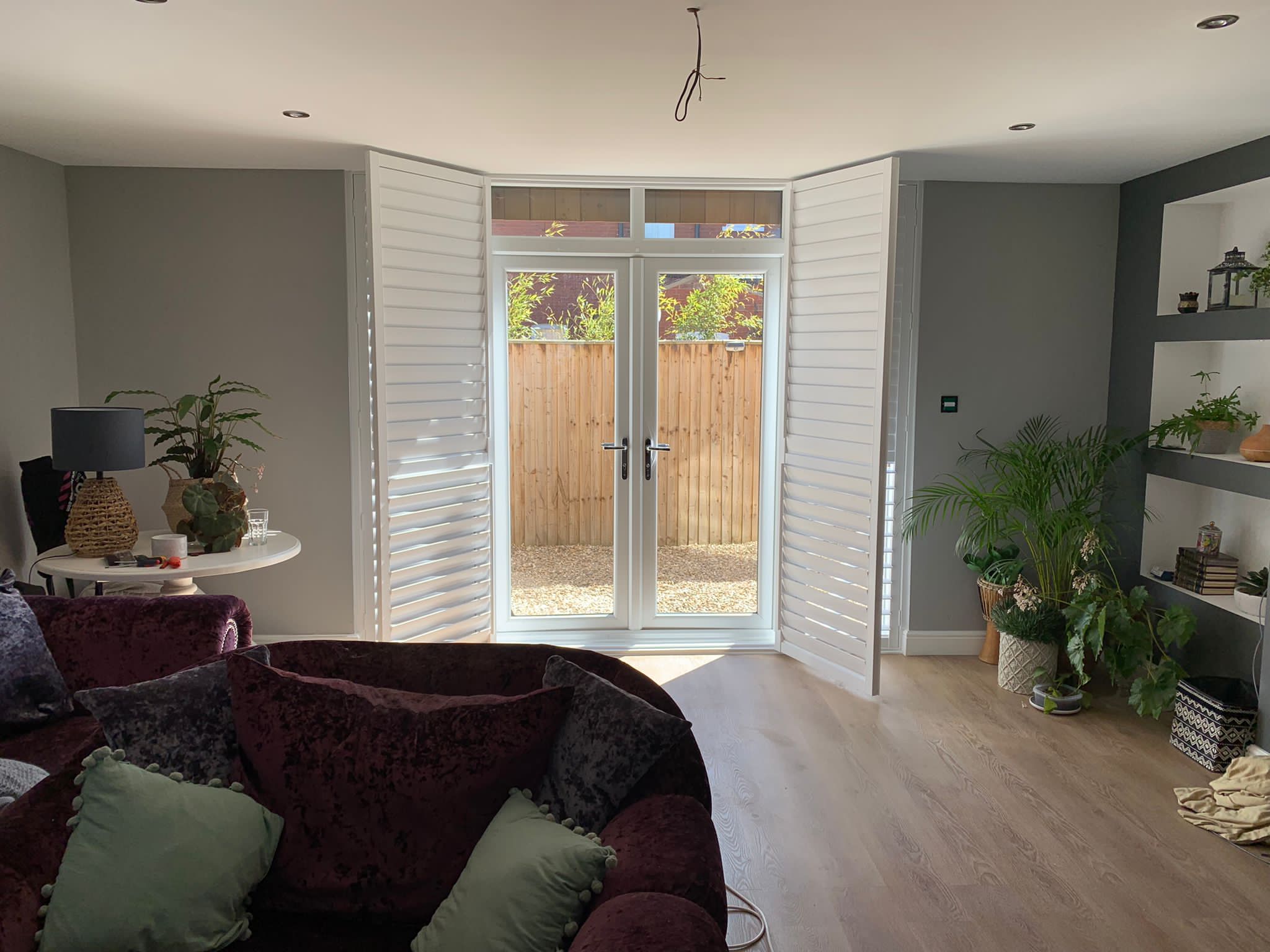 A living room with wooden shutters and a sliding door.