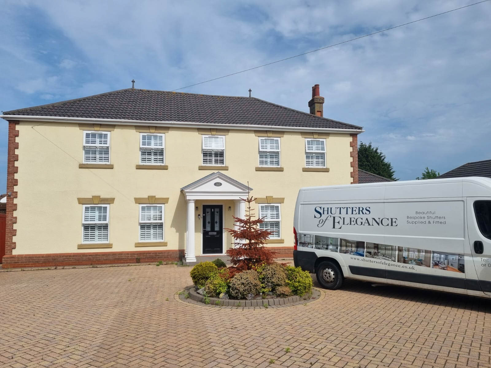 A white van parked in front of a house.