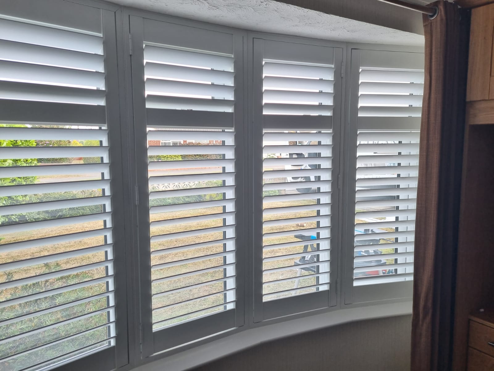 White shutters on a window in a room.