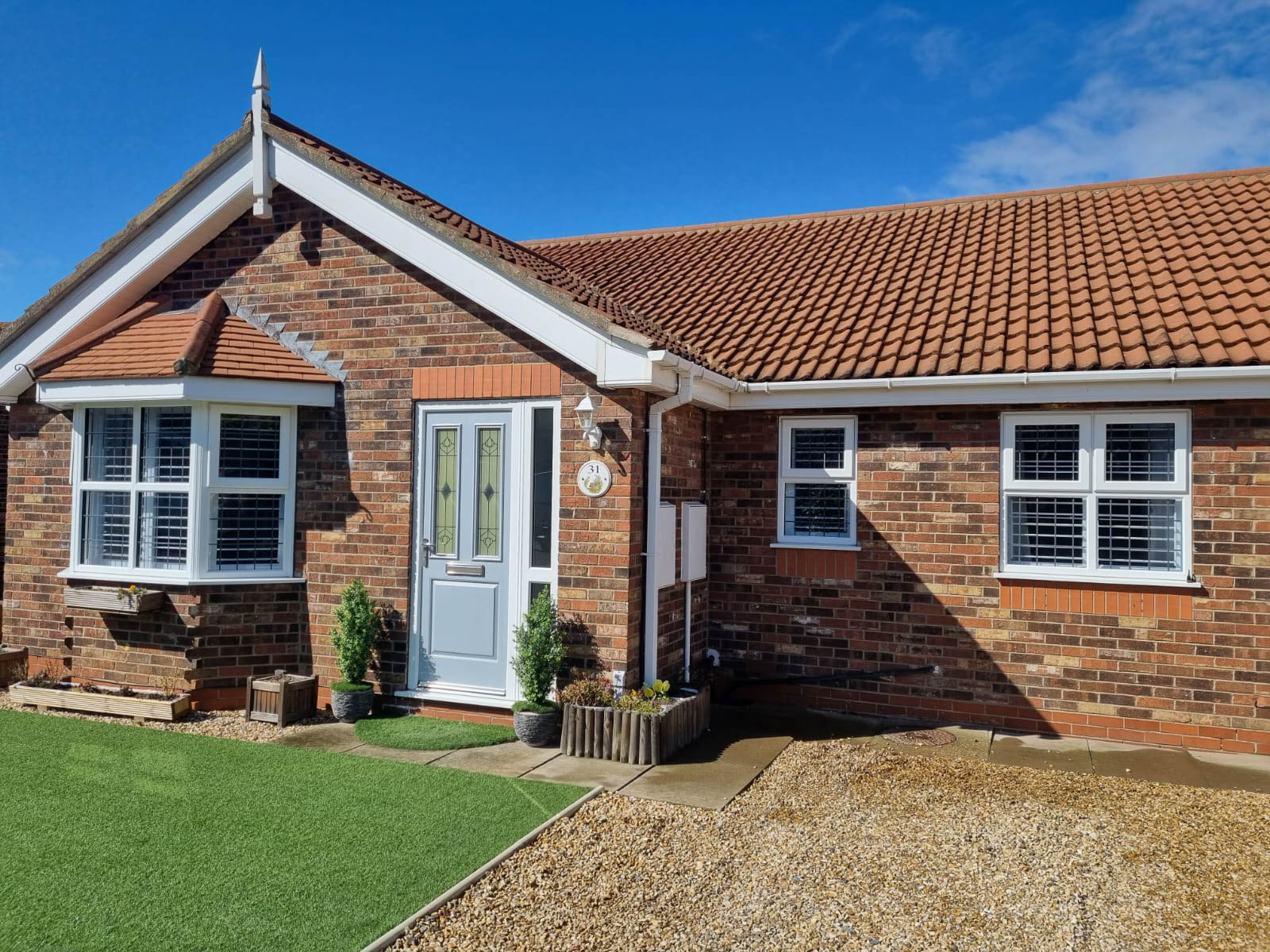 A brick house with a lawn in front of it.