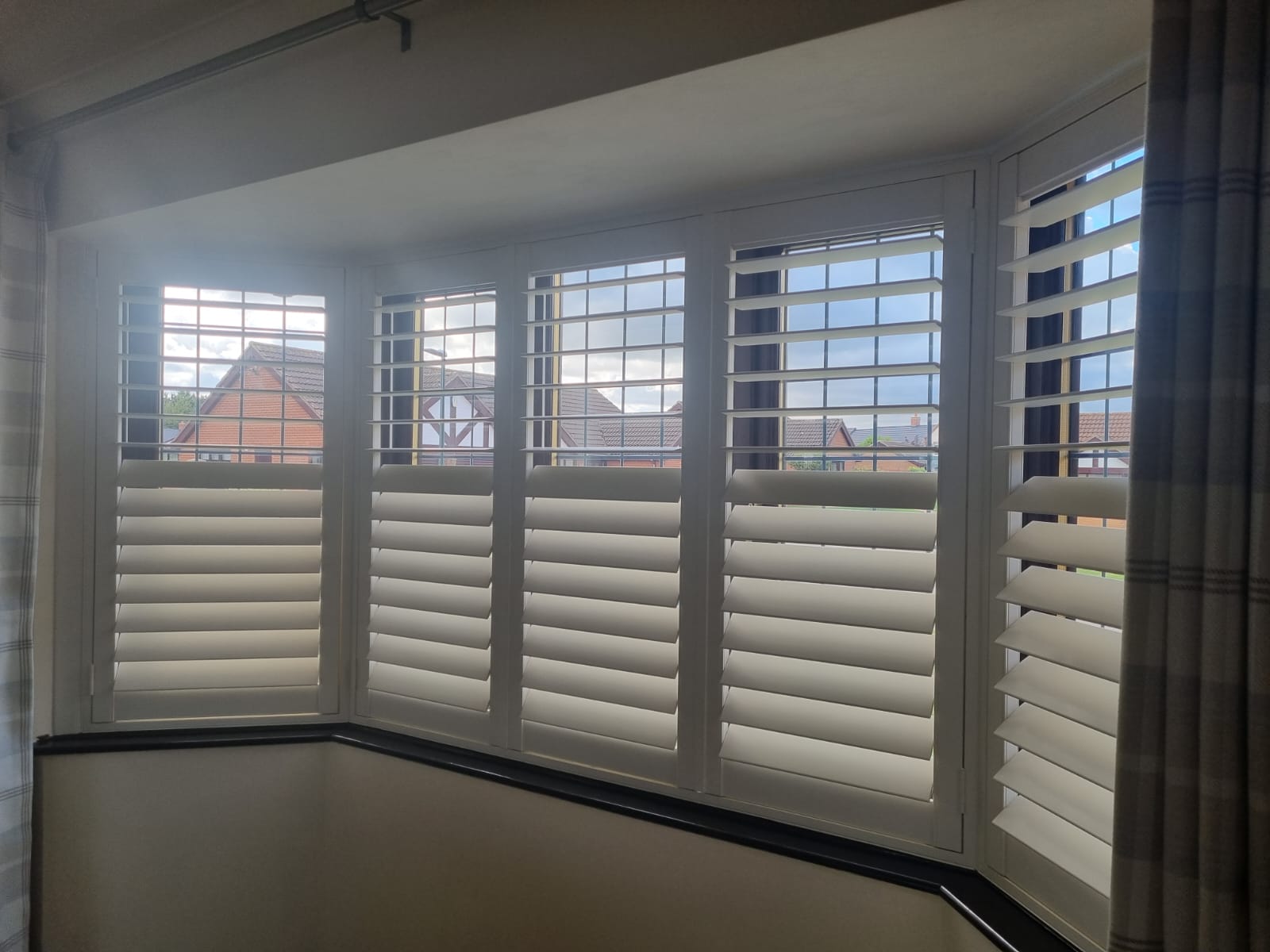 White shutters on a window in a room.