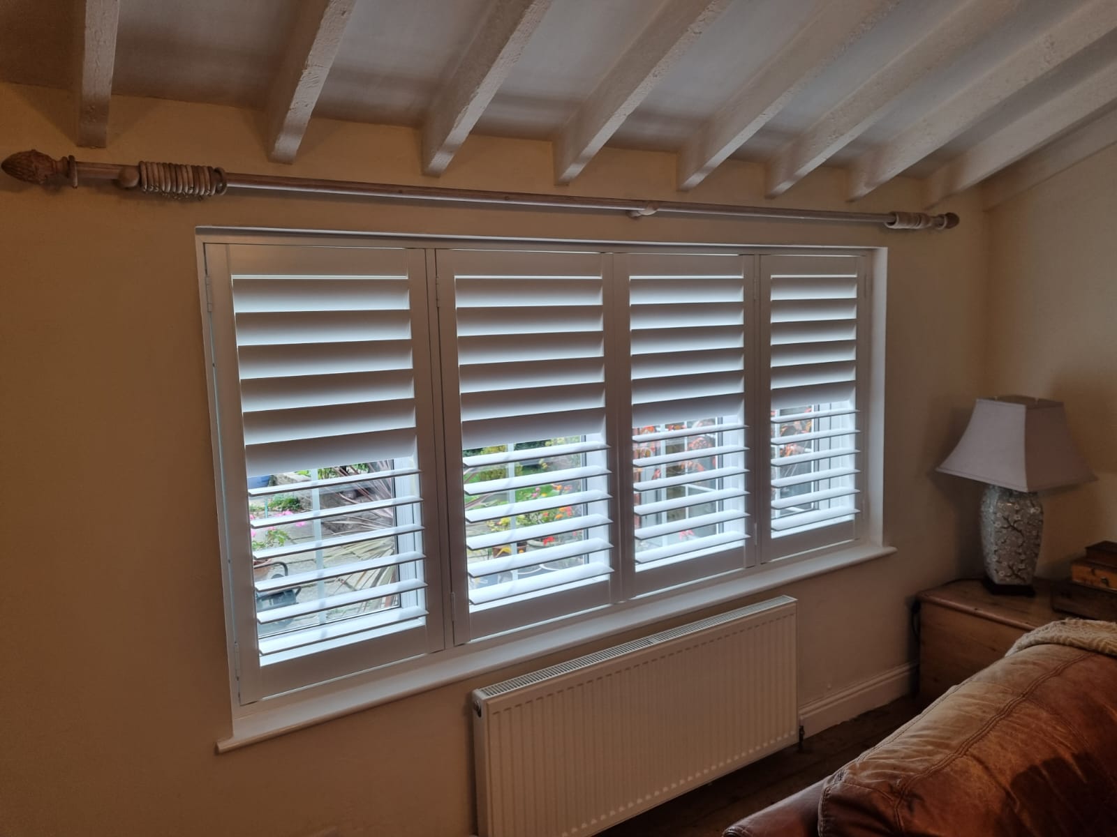 White shutters on a window in a living room.