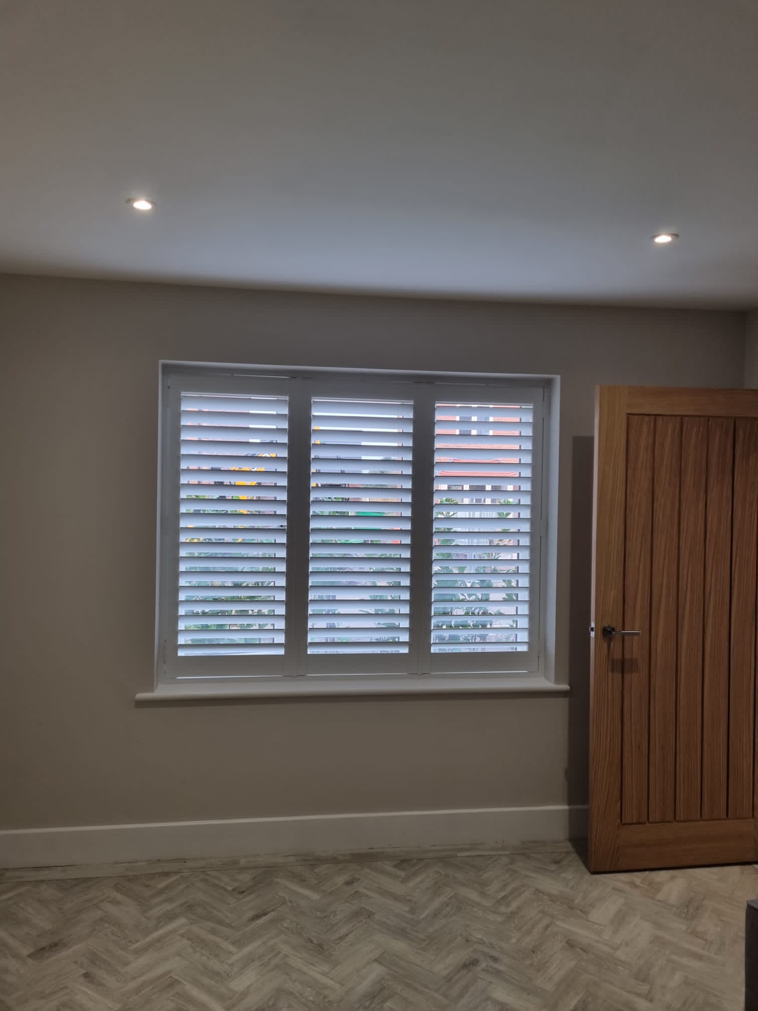 A room with wooden shutters and a door.