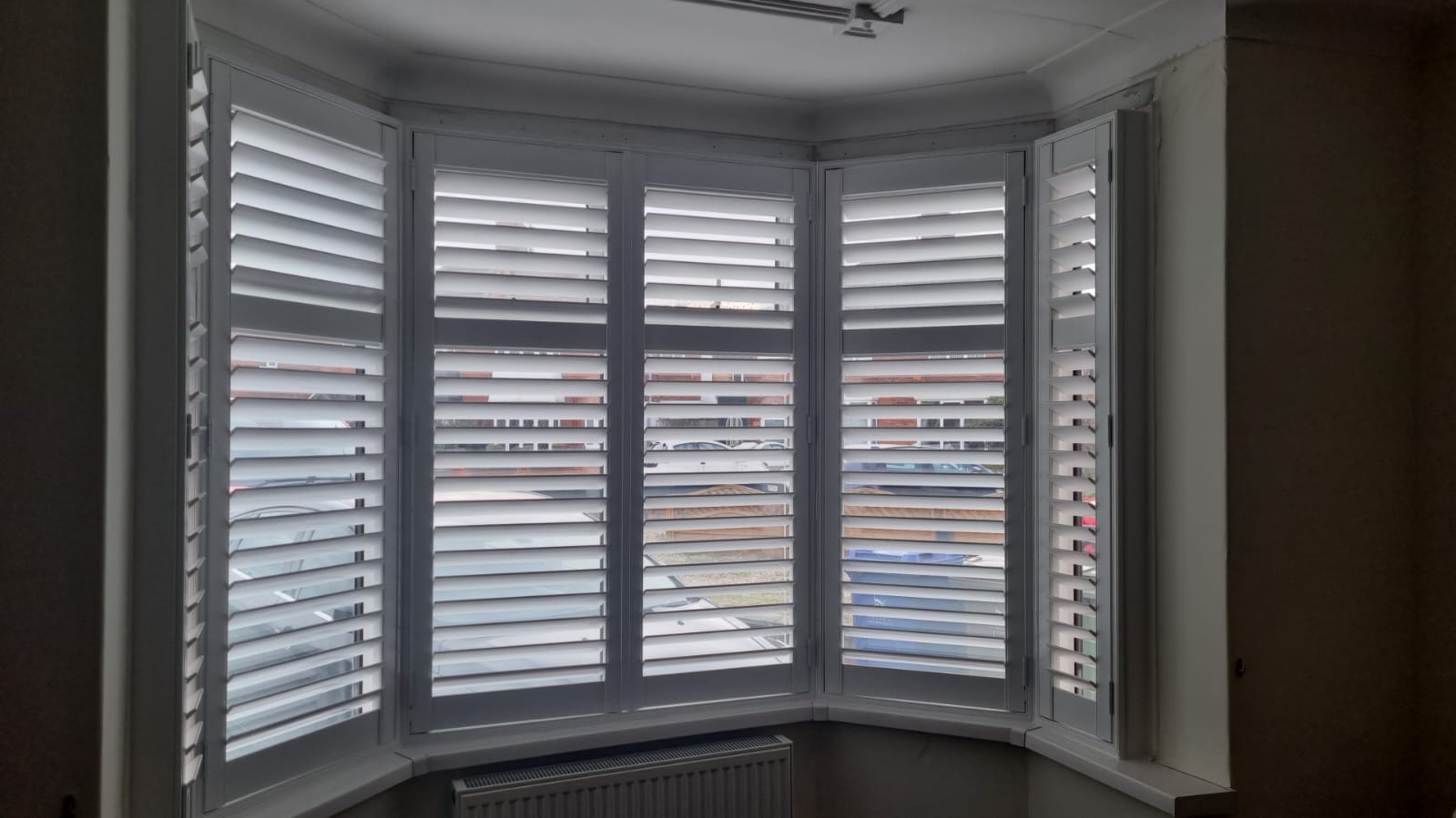 White shutters in a window in a room.