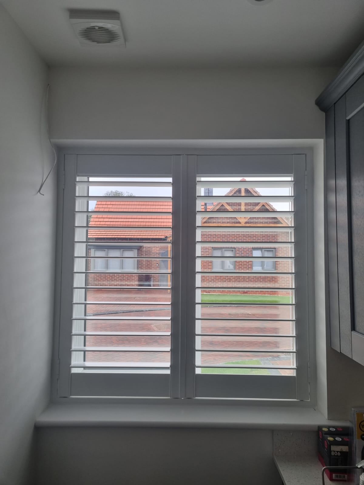 White shutters in a kitchen window.