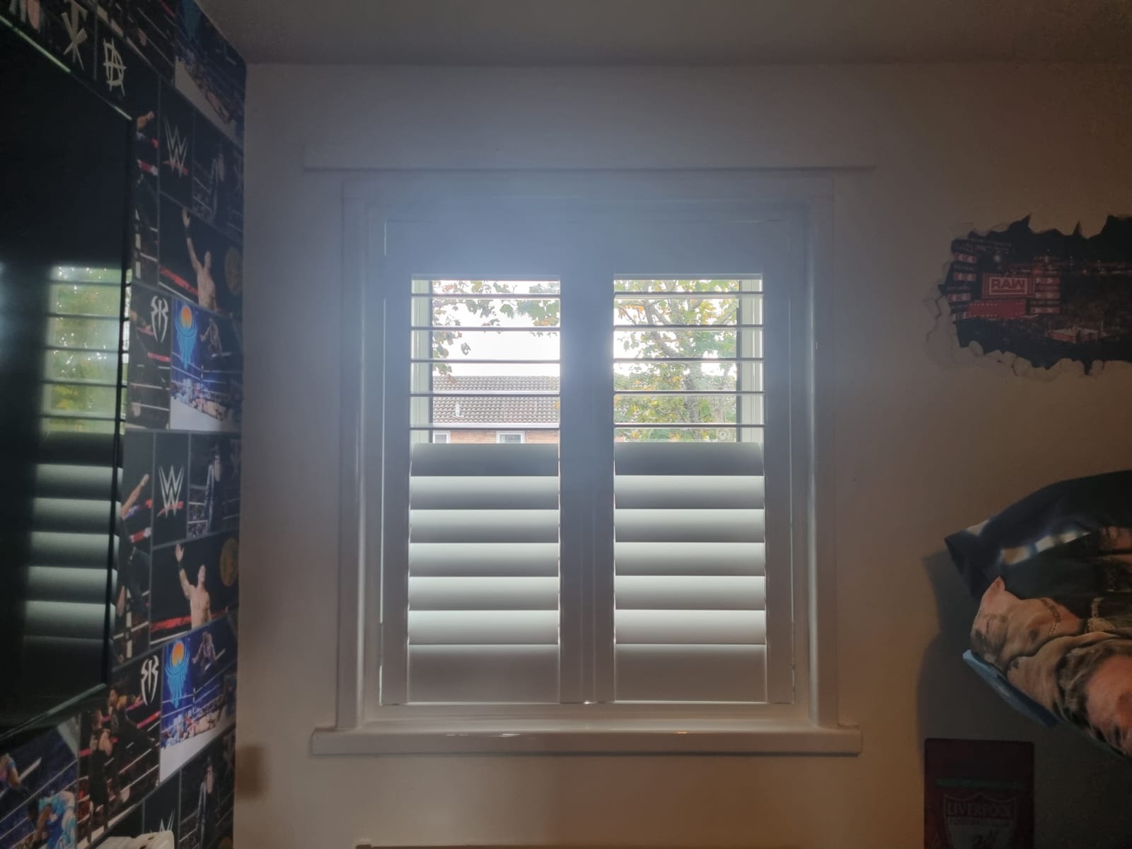 A window in a bedroom with a tv in it.