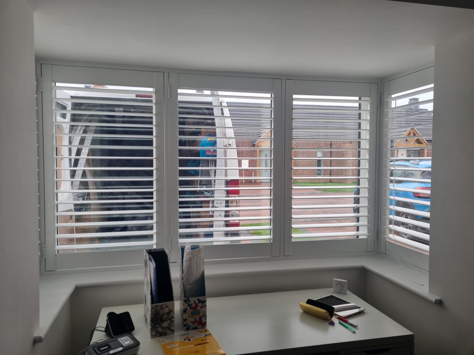 White shutters on a window in a room.