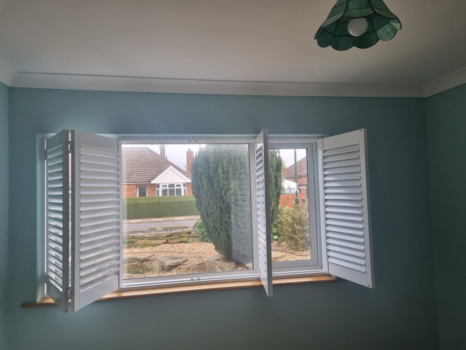 White shutters in a room with blue walls.