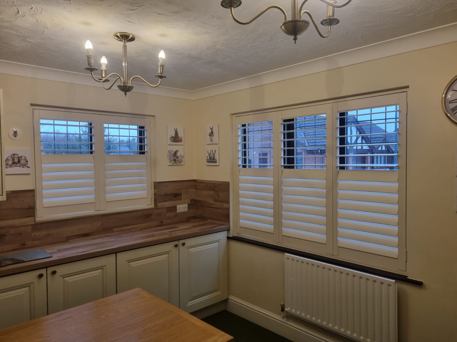 A kitchen with wooden shutters and a clock.