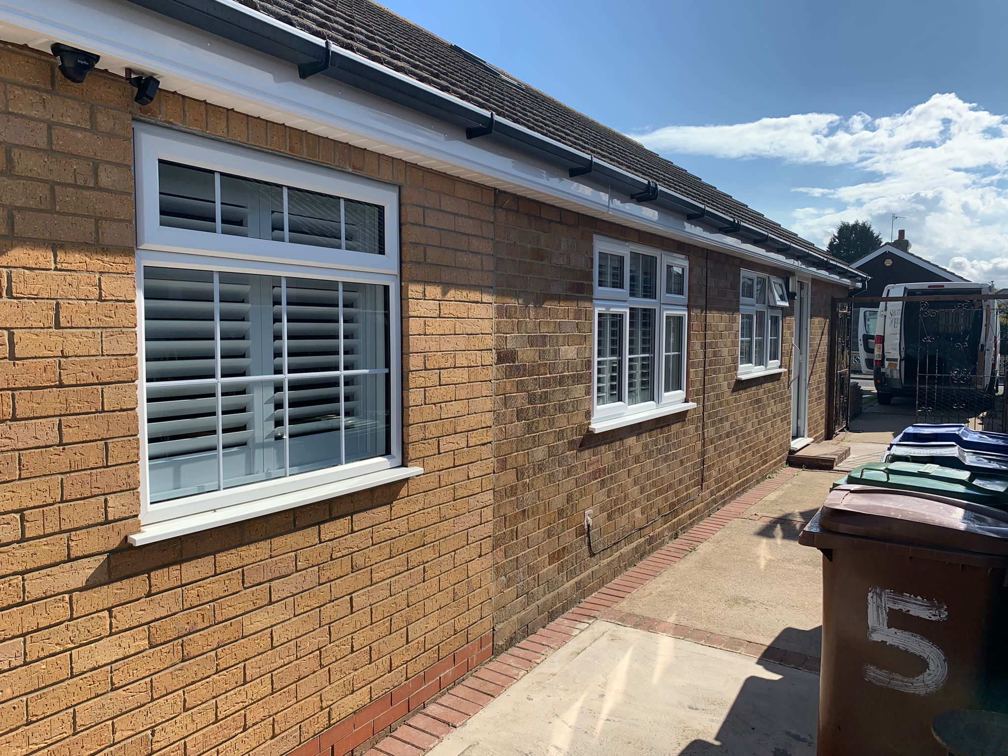 A brick house with shutters on the side of it.