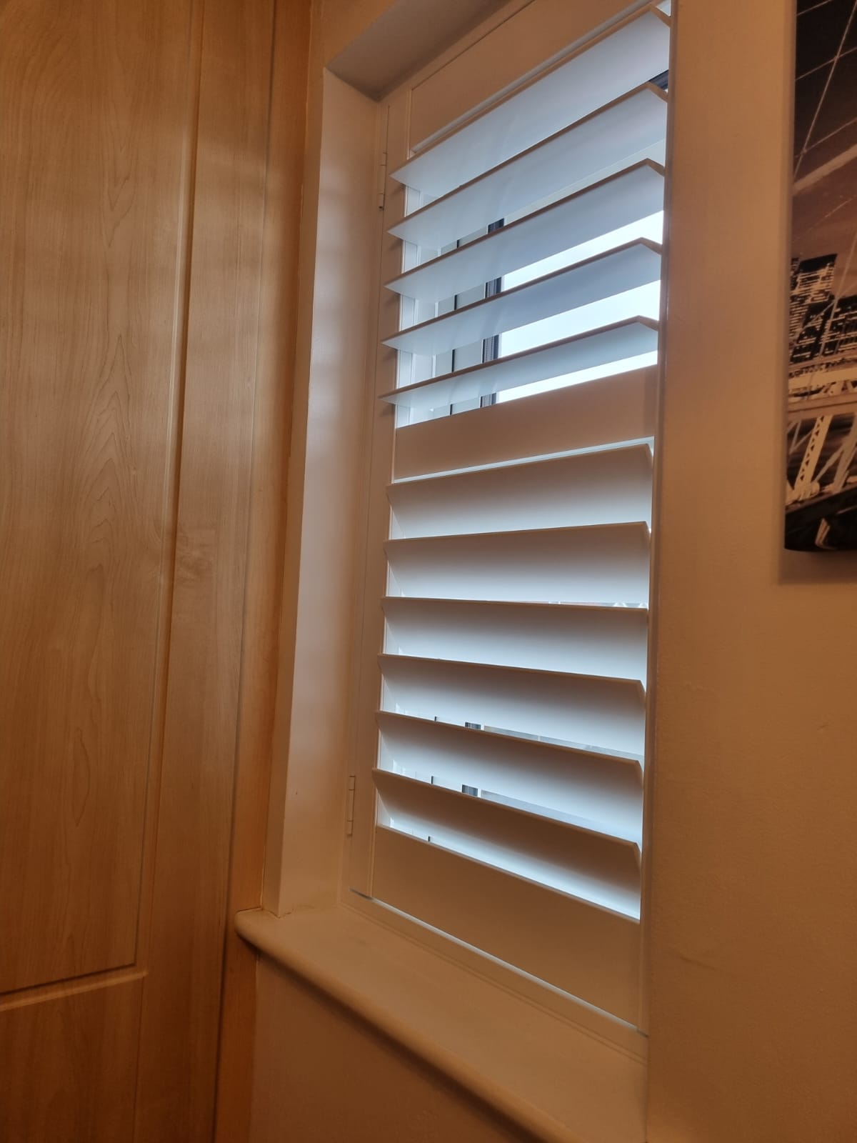 White shutters on a window in a room.