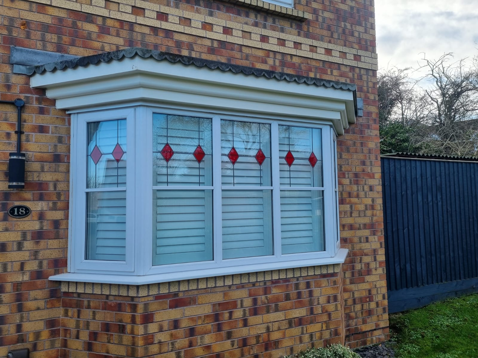 A brick house with a window in front of it.