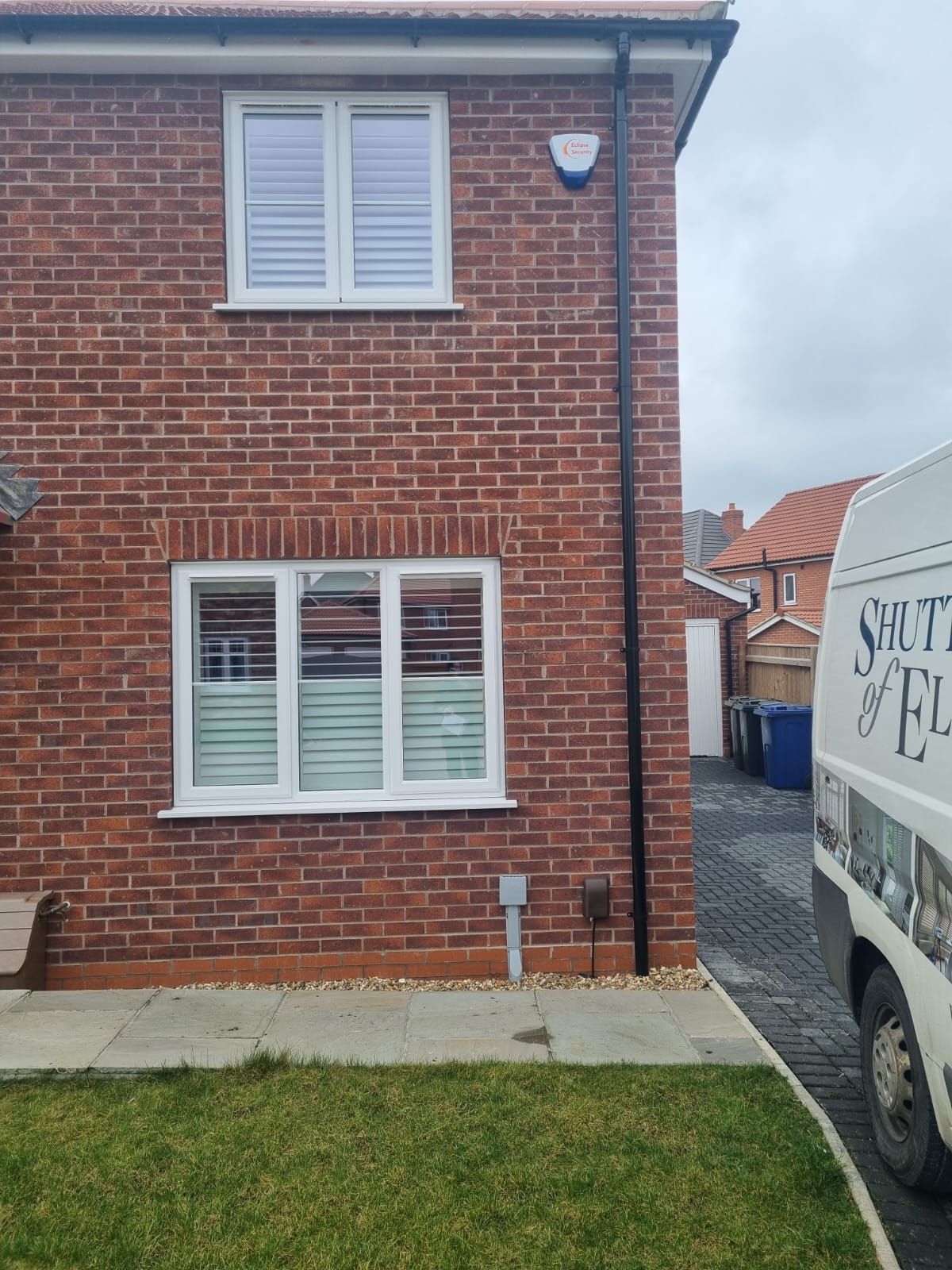 A van is parked in front of a brick house.
